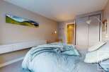 This cozy bedroom features a comfortable bed with soft bedding and a stylish throw blanket.