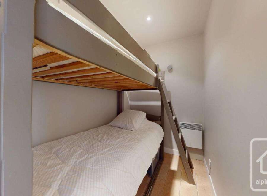 This cozy bedroom features a bunk bed, perfect for accommodating guests or family members.
