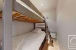 This cozy bedroom features a bunk bed, perfect for accommodating guests or family members.