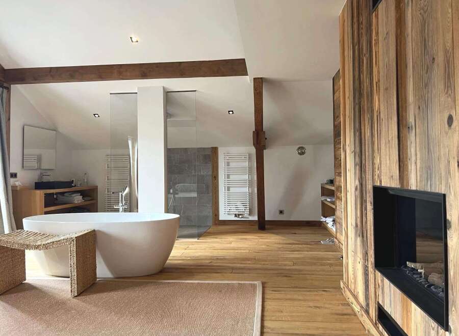 Experience luxury in this stunning bathroom featuring a modern freestanding tub and a cozy fireplace.