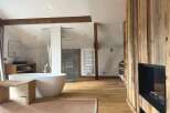 Experience luxury in this stunning bathroom featuring a modern freestanding tub and a cozy fireplace.