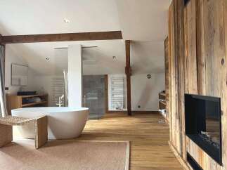 Experience luxury in this stunning bathroom featuring a modern freestanding tub and a cozy fireplace.