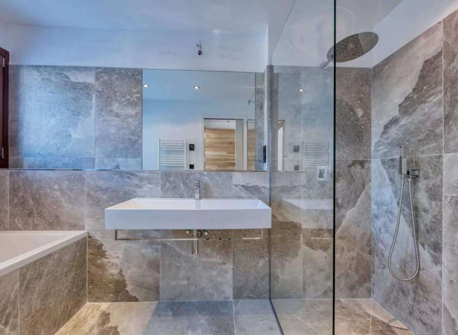 This luxurious bathroom boasts a modern design with stunning marble-like tiles.