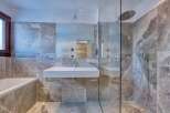 This luxurious bathroom boasts a modern design with stunning marble-like tiles.