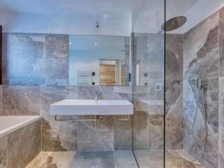 This luxurious bathroom boasts a modern design with stunning marble-like tiles.