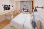 Step into this cozy bedroom, featuring a stylish desk area perfect for work or relaxation.
