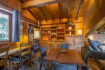 Step into this cozy cabin retreat, featuring a rustic wooden interior and a charming dining area.