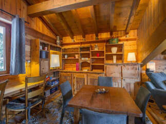 Step into this cozy cabin retreat, featuring a rustic wooden interior and a charming dining area.