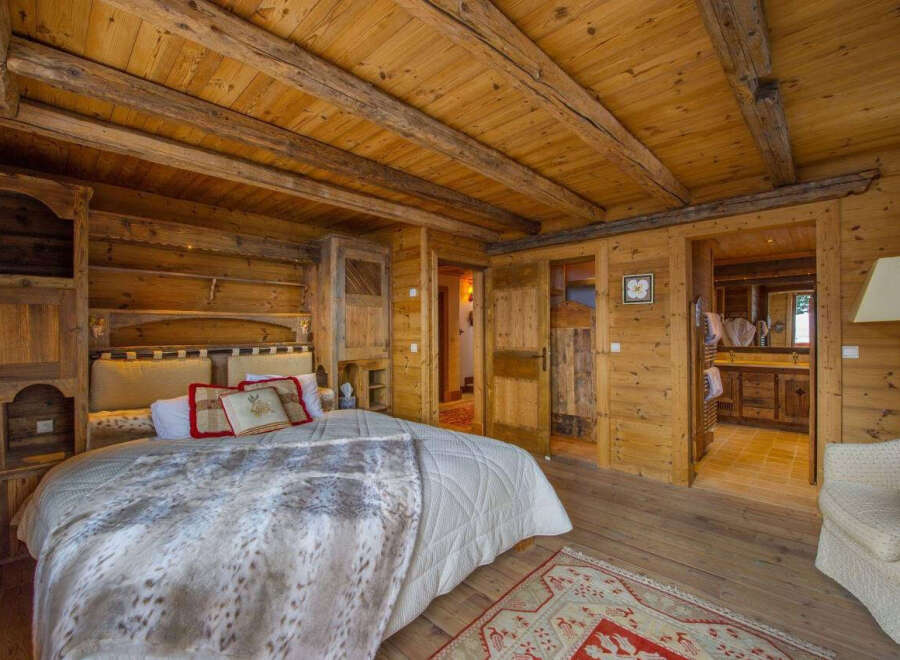 Experience rustic elegance in this stunning bedroom featuring warm wooden accents throughout.