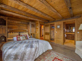 Experience rustic elegance in this stunning bedroom featuring warm wooden accents throughout.