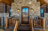 This stunning mountain home boasts a beautiful stone facade and a welcoming wooden door.