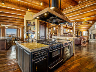 Experience luxury living in this stunning log home, featuring a gourmet kitchen with a professional-grade range and a spacious island.