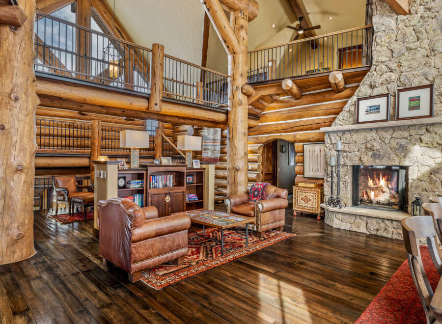 Experience rustic luxury in this stunning log home, featuring a grand stone fireplace and soaring ceilings.