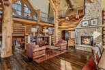 Experience rustic luxury in this stunning log home, featuring a grand stone fireplace and soaring ceilings.