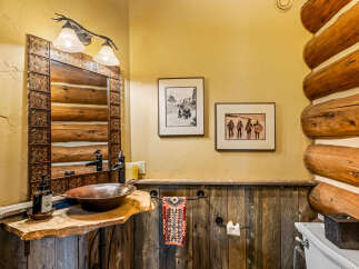 Step into rustic elegance with this stunning bathroom, featuring a unique log cabin aesthetic.