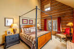 Step into luxury with this stunning bedroom featuring a majestic four-poster bed and rustic log cabin accents.