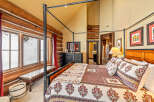 Experience rustic charm in this stunning bedroom featuring a four-poster bed and log cabin-style walls.