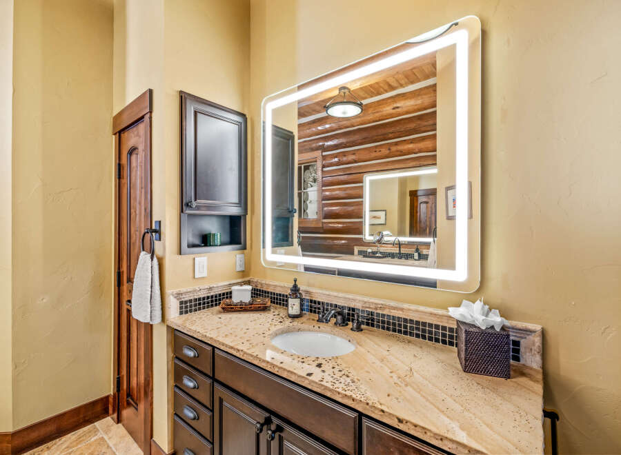 This stunning bathroom features a modern lighted mirror, adding a touch of elegance to the space.