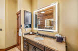 This stunning bathroom features a modern lighted mirror, adding a touch of elegance to the space.