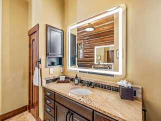 This stunning bathroom features a modern lighted mirror, adding a touch of elegance to the space.