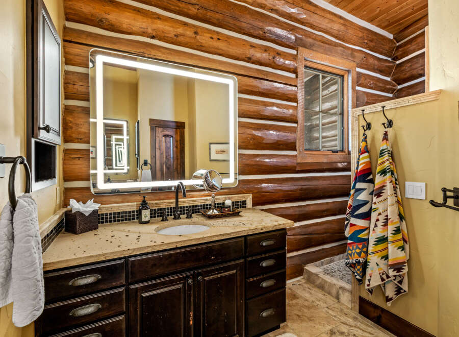 Step into luxury with this stunning bathroom featuring a rustic log cabin aesthetic.