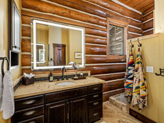 Step into luxury with this stunning bathroom featuring a rustic log cabin aesthetic.