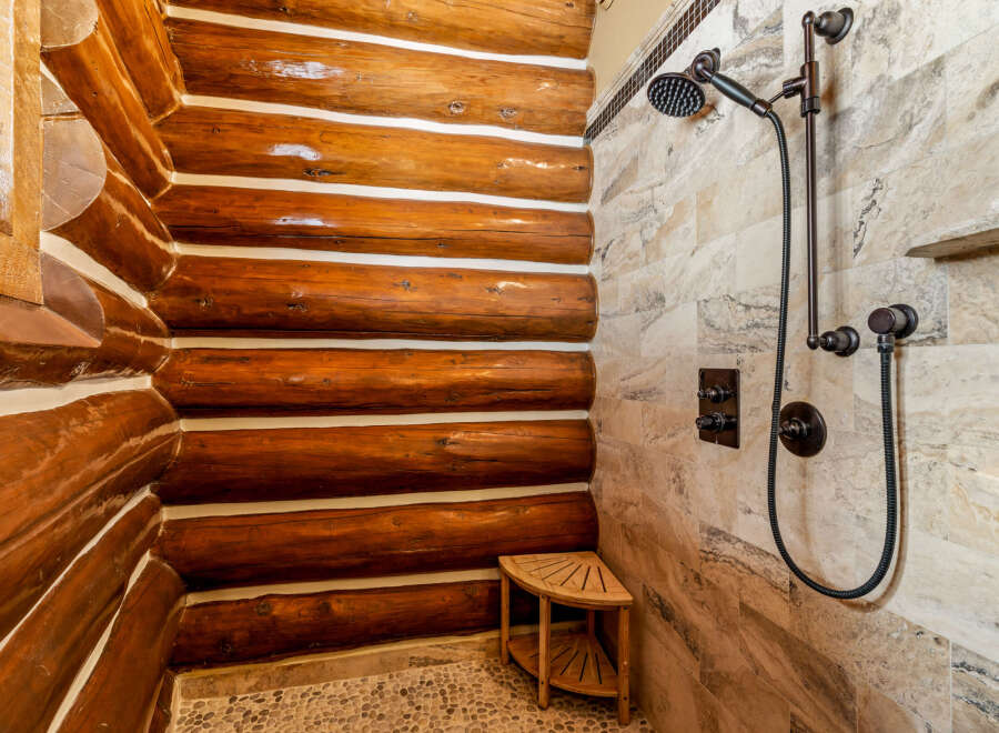 Step into luxury with this stunning bathroom featuring a unique log cabin-style shower.