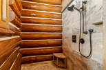 Step into luxury with this stunning bathroom featuring a unique log cabin-style shower.
