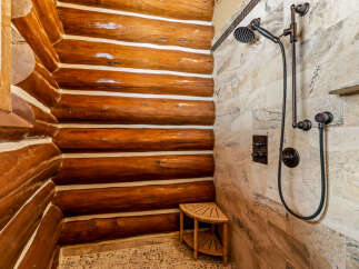 Step into luxury with this stunning bathroom featuring a unique log cabin-style shower.