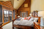 Experience rustic luxury in this stunning bedroom featuring exposed log walls and a cozy ambiance.