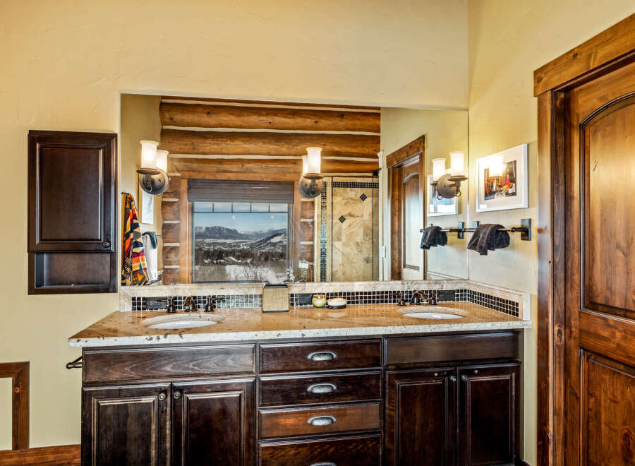This stunning bathroom features a luxurious double vanity with a granite countertop and dark wood cabinetry.
