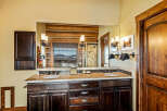 This stunning bathroom features a luxurious double vanity with a granite countertop and dark wood cabinetry.