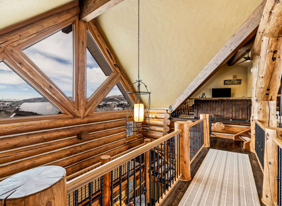 This stunning log cabin home features a unique architectural design with exposed wooden beams and a cozy, inviting atmosphere.