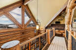 This stunning log cabin home features a unique architectural design with exposed wooden beams and a cozy, inviting atmosphere.