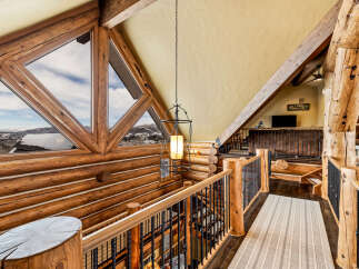 This stunning log cabin home features a unique architectural design with exposed wooden beams and a cozy, inviting atmosphere.