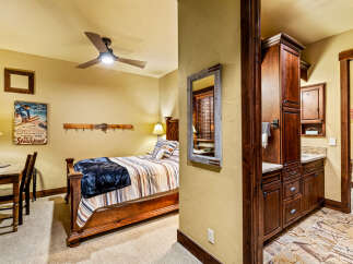 This cozy bedroom features a rustic wooden bed frame, complemented by a warm color palette and inviting decor.