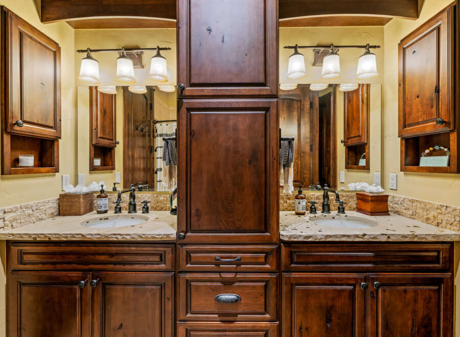 This stunning bathroom boasts a luxurious double vanity with rich, dark wood cabinetry, offering ample storage and a touch of elegance.