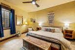 This cozy bedroom features a rustic aesthetic with a wooden chest at the foot of the bed.