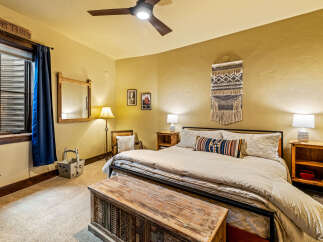 This cozy bedroom features a rustic aesthetic with a wooden chest at the foot of the bed.