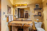 This rustic bathroom showcases a unique stone sink and a wooden vanity, creating a warm and inviting atmosphere.