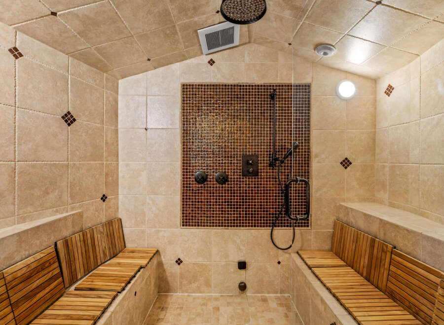 Step into luxury with this spa-like shower! Featuring a stunning mosaic tile accent wall, this shower offers a relaxing retreat.