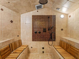 Step into luxury with this spa-like shower! Featuring a stunning mosaic tile accent wall, this shower offers a relaxing retreat.