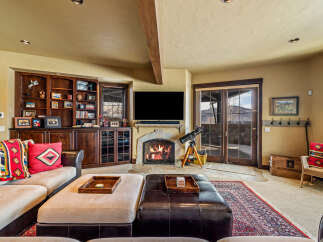 Step into luxury with this stunning living room, featuring a cozy fireplace and a built-in entertainment center.
