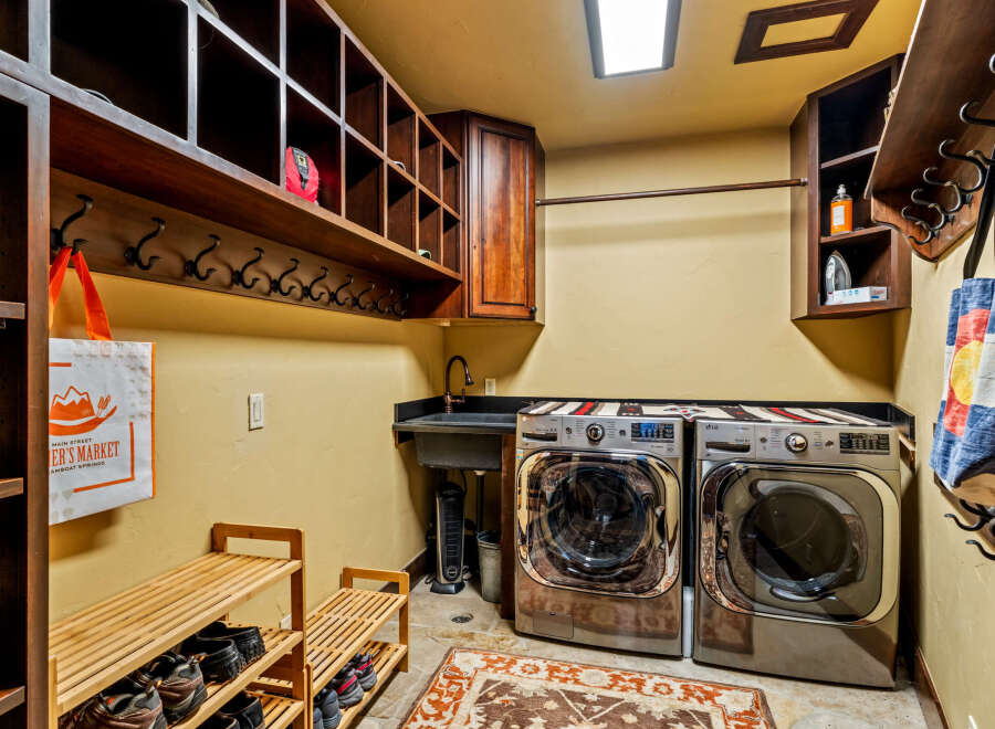 This laundry room boasts a functional design with ample storage and modern appliances.