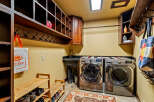 This laundry room boasts a functional design with ample storage and modern appliances.