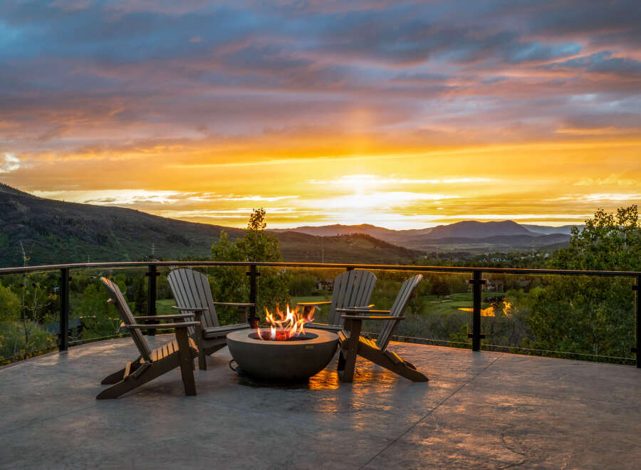 Enjoy breathtaking sunsets from this stunning property, featuring a cozy outdoor seating area with a fire pit.