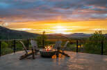 Enjoy breathtaking sunsets from this stunning property, featuring a cozy outdoor seating area with a fire pit.