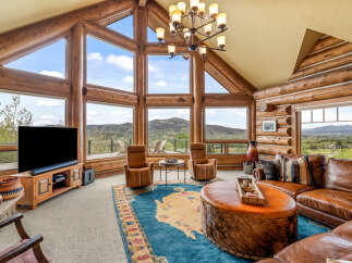 Experience luxury living in this stunning log cabin home, boasting breathtaking mountain views and an abundance of natural light.