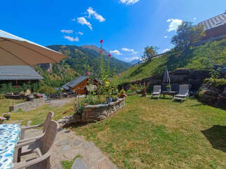Escape to this charming mountain retreat! This property boasts stunning views, a lush green lawn, and a cozy patio area perfect for relaxation.