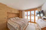 Experience the charm of this cozy bedroom featuring natural wood accents and a stunning view.